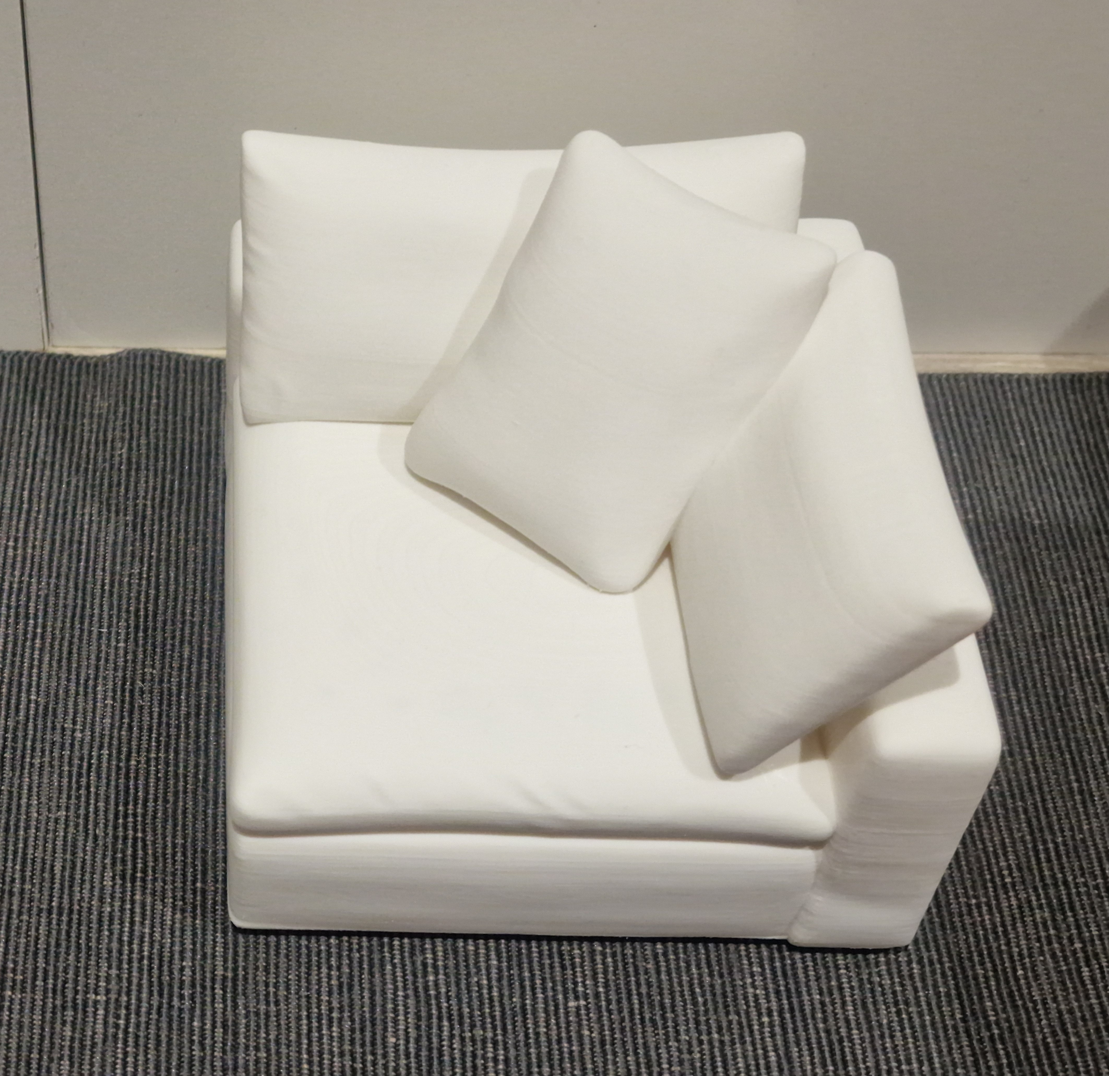 White 3D printed miniature sofa corner module with a backrest, side rest and pillow details.