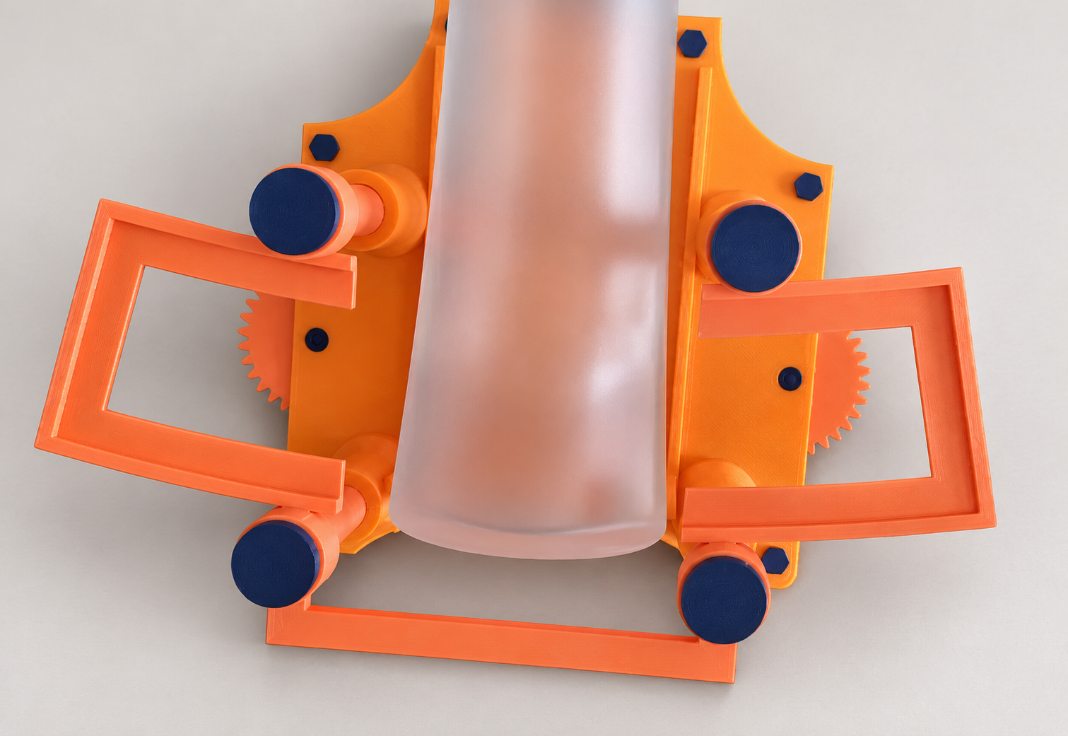 Orange bottle labelling jig holding a frosted bottle, with dark blue adjustment pads on a light grey background.
